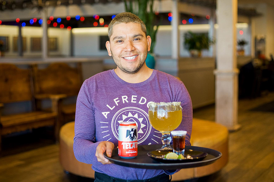 Alfredo's Mexican Cafe Server holding tray with Tecate beer